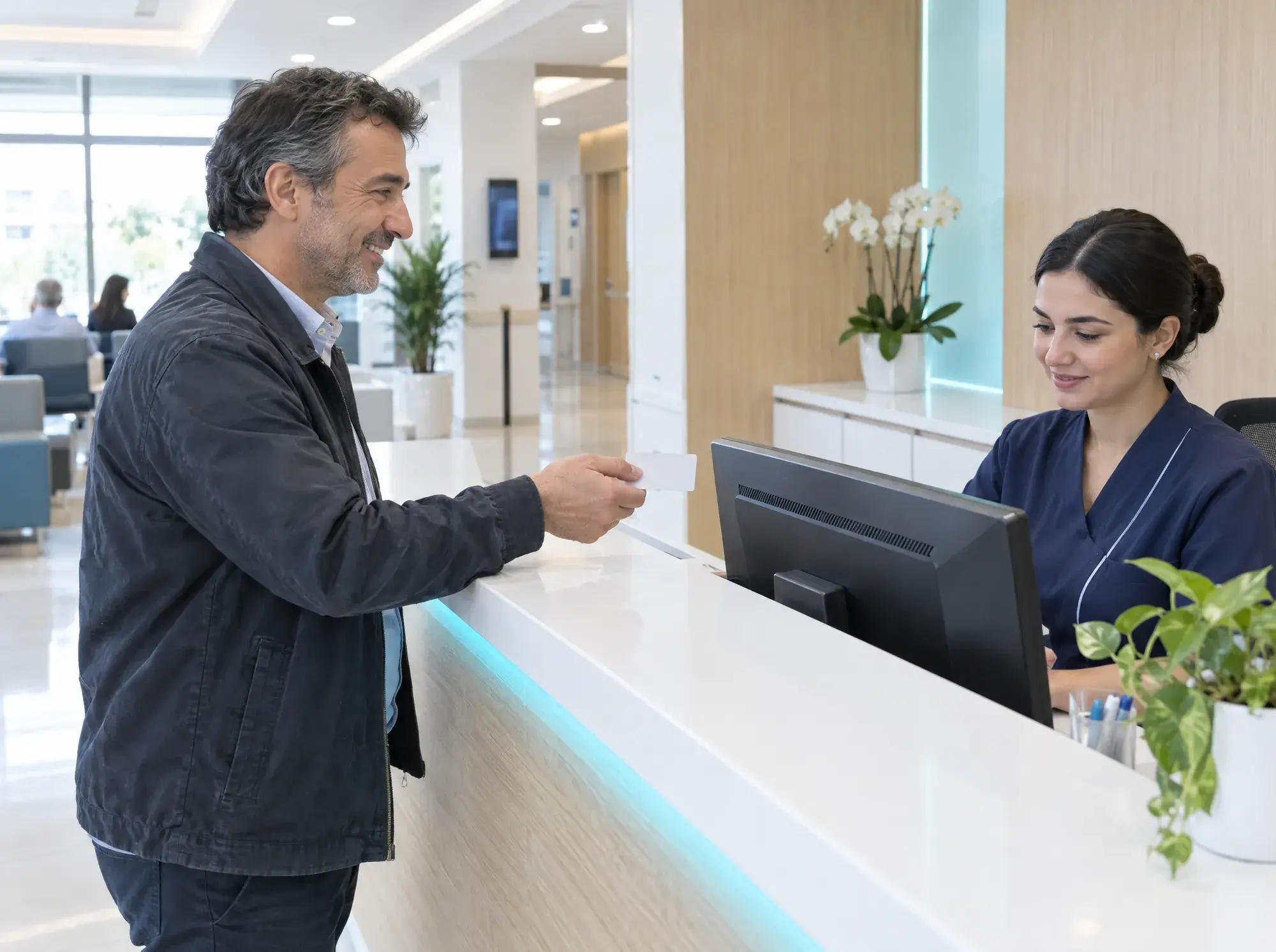 Hastane danışmasında sigorta kartını teslim eden hasta